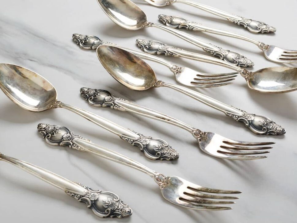 antique vintage spoons and fork with decorative handles on white table